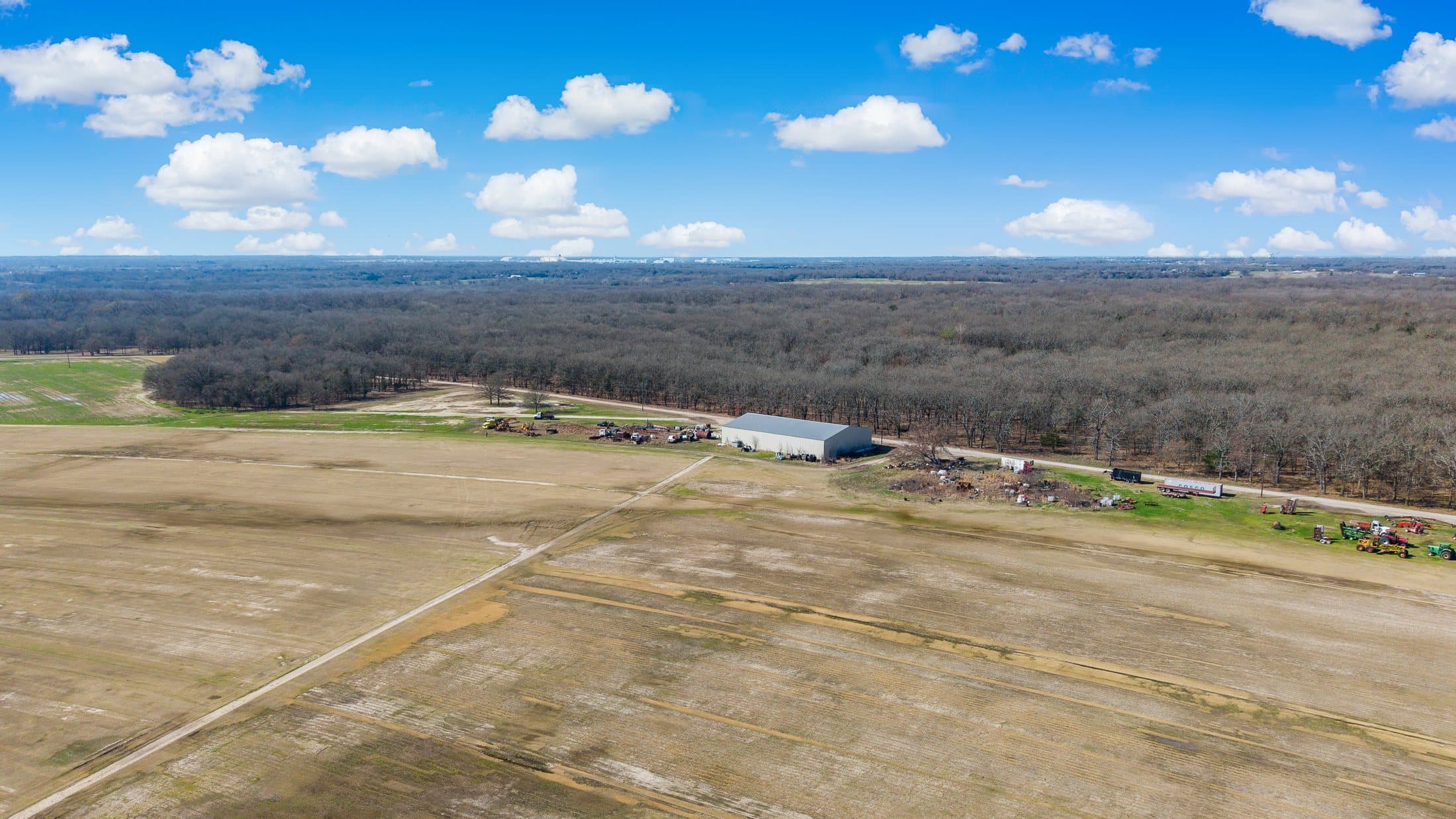 Drone view across the primary site fields toward the horizon
