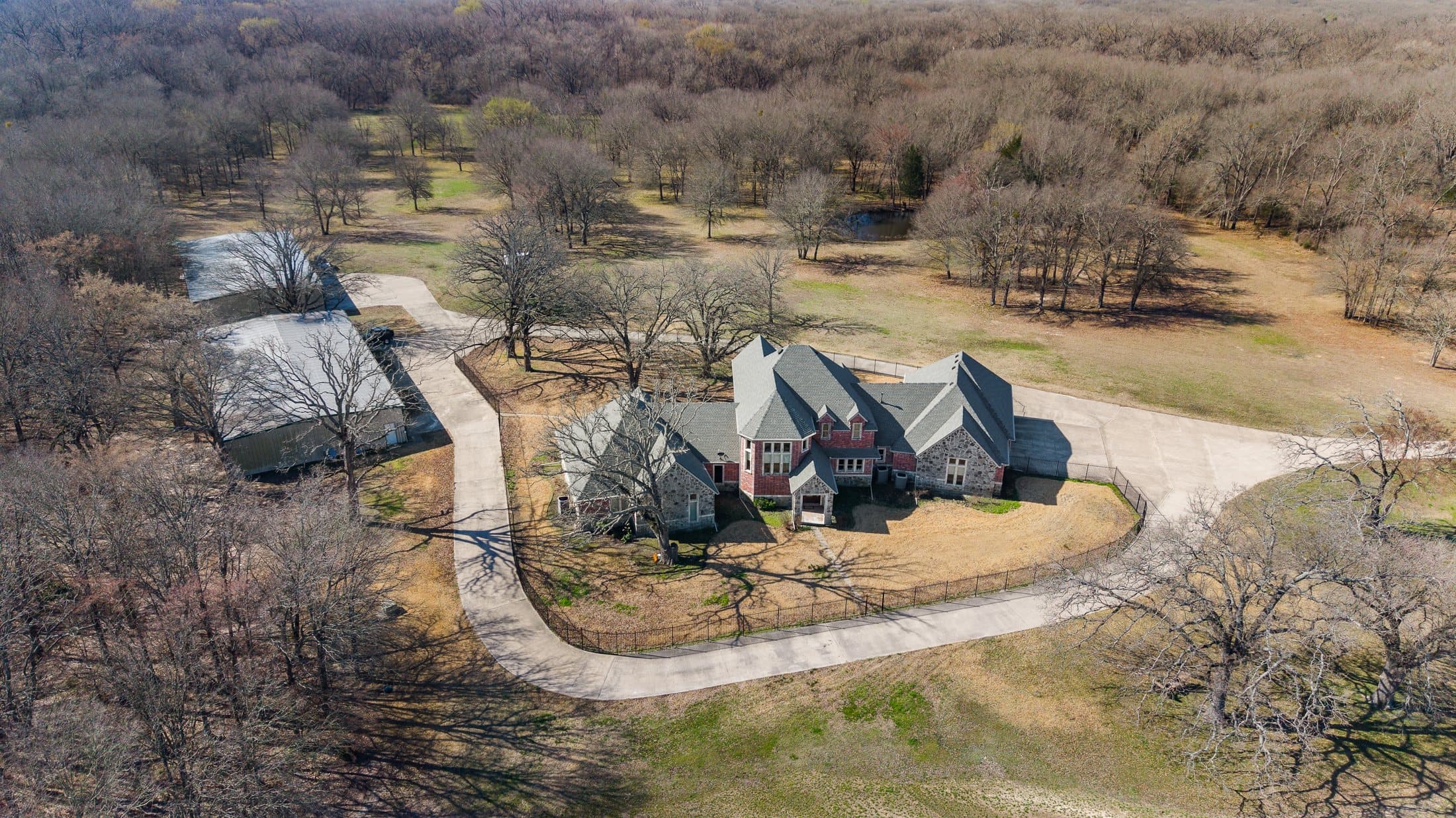 Aerial of mature tree-lined acreage adjoining the primary production fields
