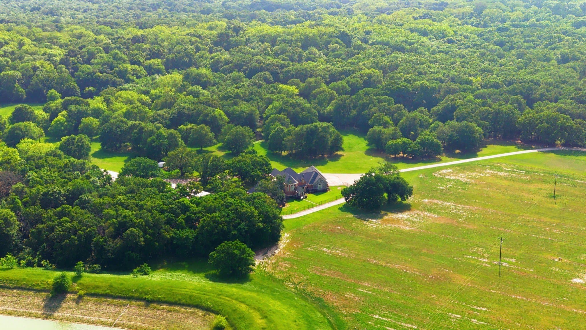 Aerial view over the 752 CR 3103 primary production site with adjacent treed acreage