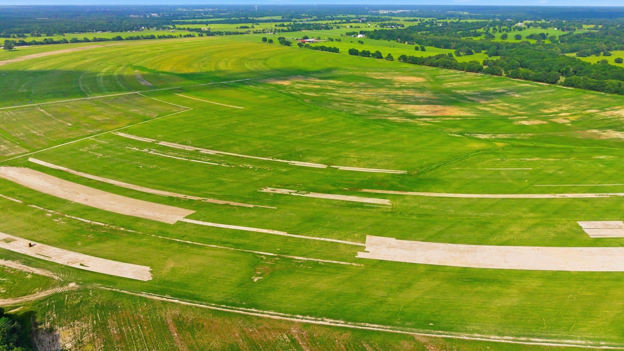 Drone view of the residence and treed acreage adjacent to the primary site