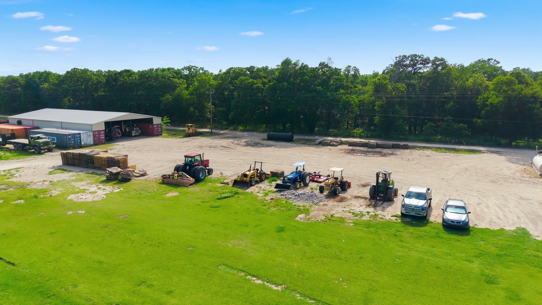 Summer aerial of the equipment yard with tractors, forklifts and trucks staged