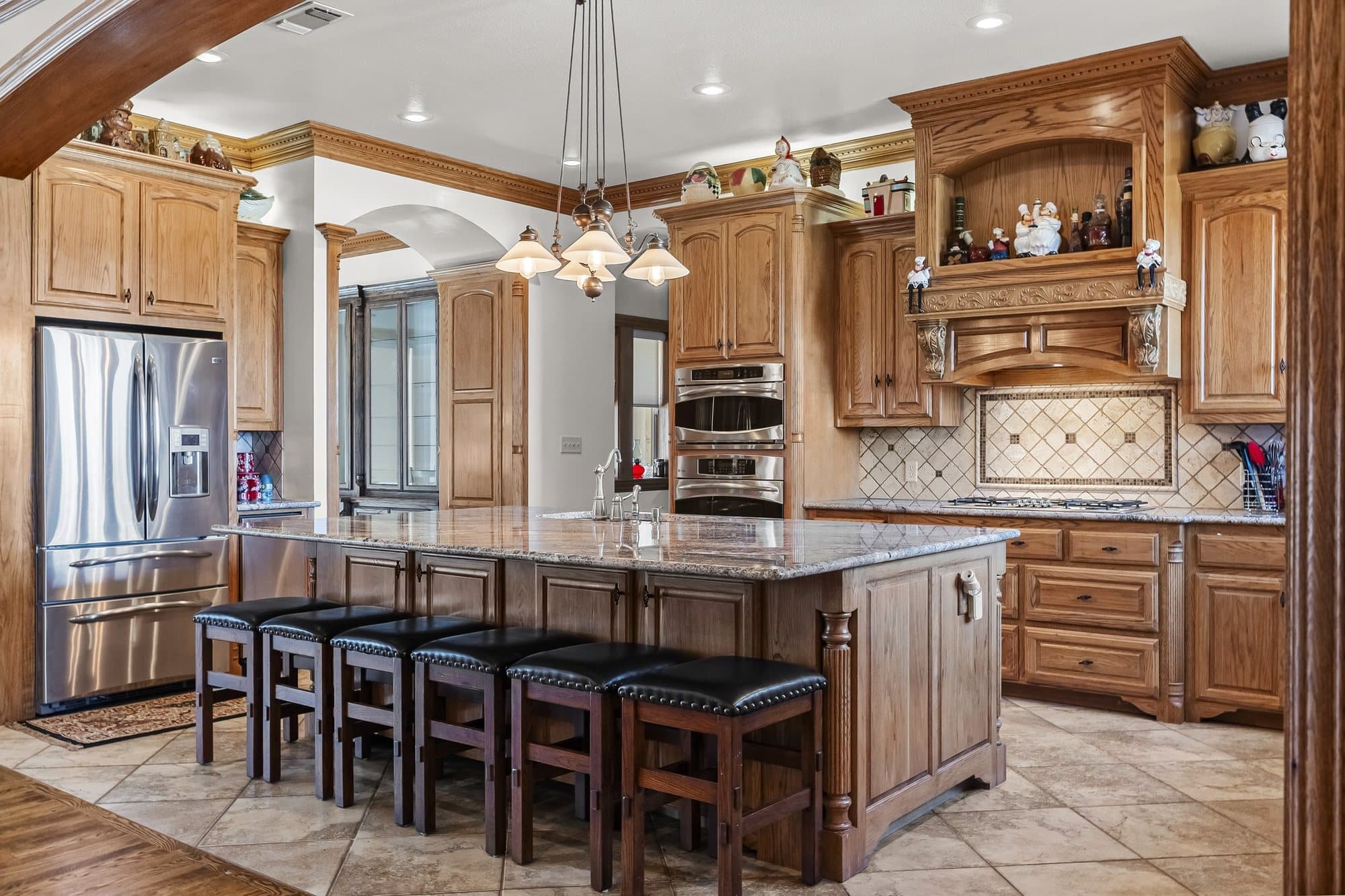Residence kitchen with large island, hardwood cabinetry, and granite countertops